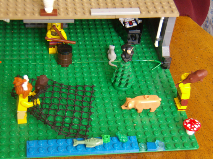 LEGO MOC - Потому что мы можем! - Пещерные люди открывают огонь.: Река и улов на берегу. Пещерная женщина постаралась и поймала сетью к обеду рыбу, лягушку и водоросли, а теперь вот-вот поймает свинью.