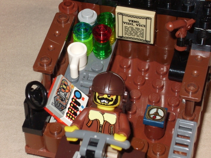 LEGO MOC - Мини-конкурс 'Битва Дирижаблей' - Небесная Акула: Взглянув в скромное убранство каюты одноглазого разбойника, можно увидеть стол с неплохим ассортиментом спиртного.Сразу видно,какие исторические личности вдохновляют этого человека.Перед любым боем он принимает смесь рома и пороха,как легендарный Капитан Черная Борода.А руководствуется простым,но действенным принципом Гая Юлия Цезаря - пришел,увидел,победил.Также в кабине присутствуют немногочисленные датчики,компас,бинокль и,конечно же,пистолет.
