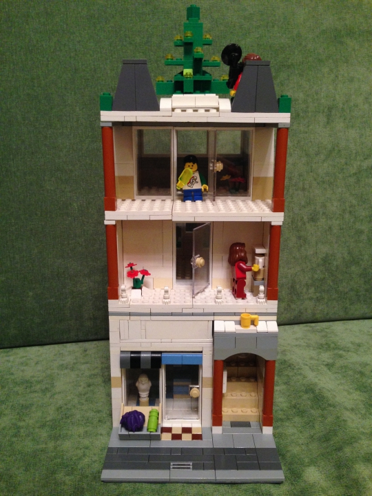 LEGO MOC - Новогодний Кубик 2014 - Прекрасный Новогодний Домик): Фасад дома достаточно красив.Всего в доме 3 этажа, на первом- магазин новогодних подарков,на втором-жилая квартира,на третьем-ремонт, а вот на крыше находится елка-главный атрибут Нового Года!