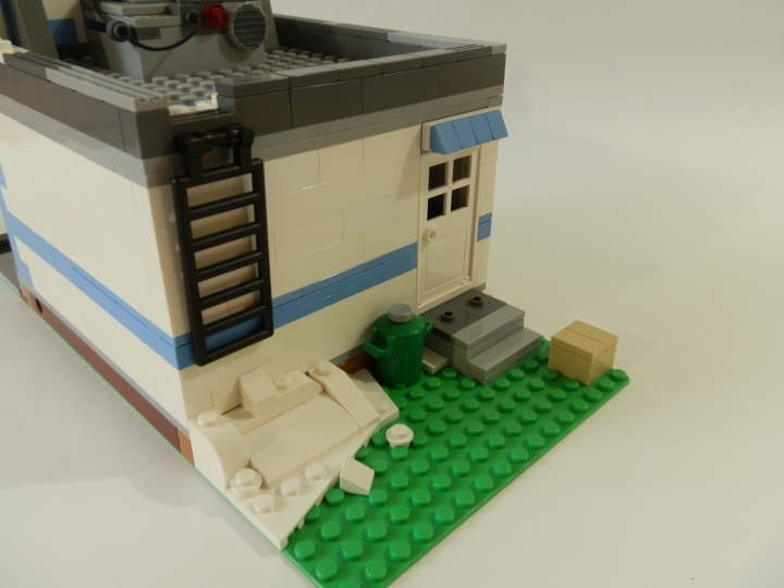 LEGO MOC - Новогодний Кубик 2014 - Магазин игрушек.: На заднем дворе расположились урна, коробка и сугроб. А к задней стенке магазина прилегает лестница, ведущая на крышу.