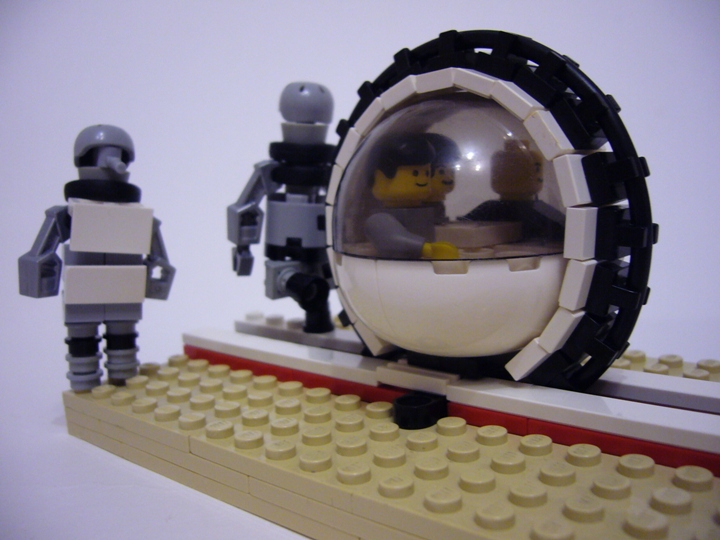 LEGO MOC - Конкурс «Советское кино» - Оригинальный запуск: На стоп кадре изображены робот-нянька (в переднике) и 739-ый, запускающий машину-монорельс с ребятами на борту.