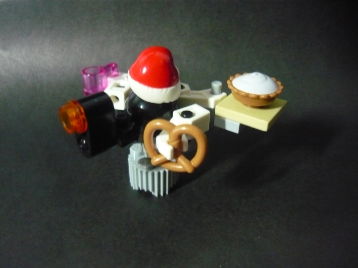 LEGO MOC - Новогодний Кубик 3015 - Новый 3015 Год: встречаем вместе!: Одна из частей работы - робот, продающий еду, тортик, крендельки, чашки с кофе :-) На него нацеплена Новогодняя шапочка, что придает праздничное настроение, хоть на дворе 3015 год, а традиции остались. И еще, не смотрите на серую деталь - она служит подставкой, потому что робот, не смог сам удержаться. На самом деле, он 'парит' в воздухе, благодаря прозрачной детальке.