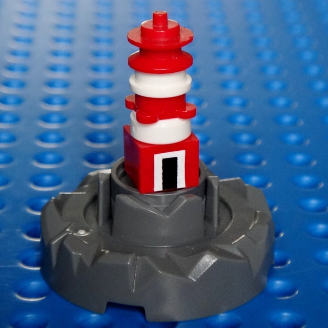 LEGO MOC - Погружение - Внеконкурсный маяк в трех масштабах (mini scale, micro scale, nano scale) : Версия маяка в масштабе 3  (nano scale) от Flickr пользователя simplybrickingit.<br />
<br />
В качестве двери и ее окантовки использованы наклейки.  Маяк собран из 7-ми деталей + 2 наклейки (белого и черного цвета)