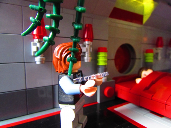 LEGO MOC - Новогодний Кубик 3015 - Земля. Новый 3015 год.: Муж с нежностью смотрит на жену, отведя взгляд от планшета.<br />
в правом углу комнаты стоит прозрачный экран выключенного голо-компьютера.